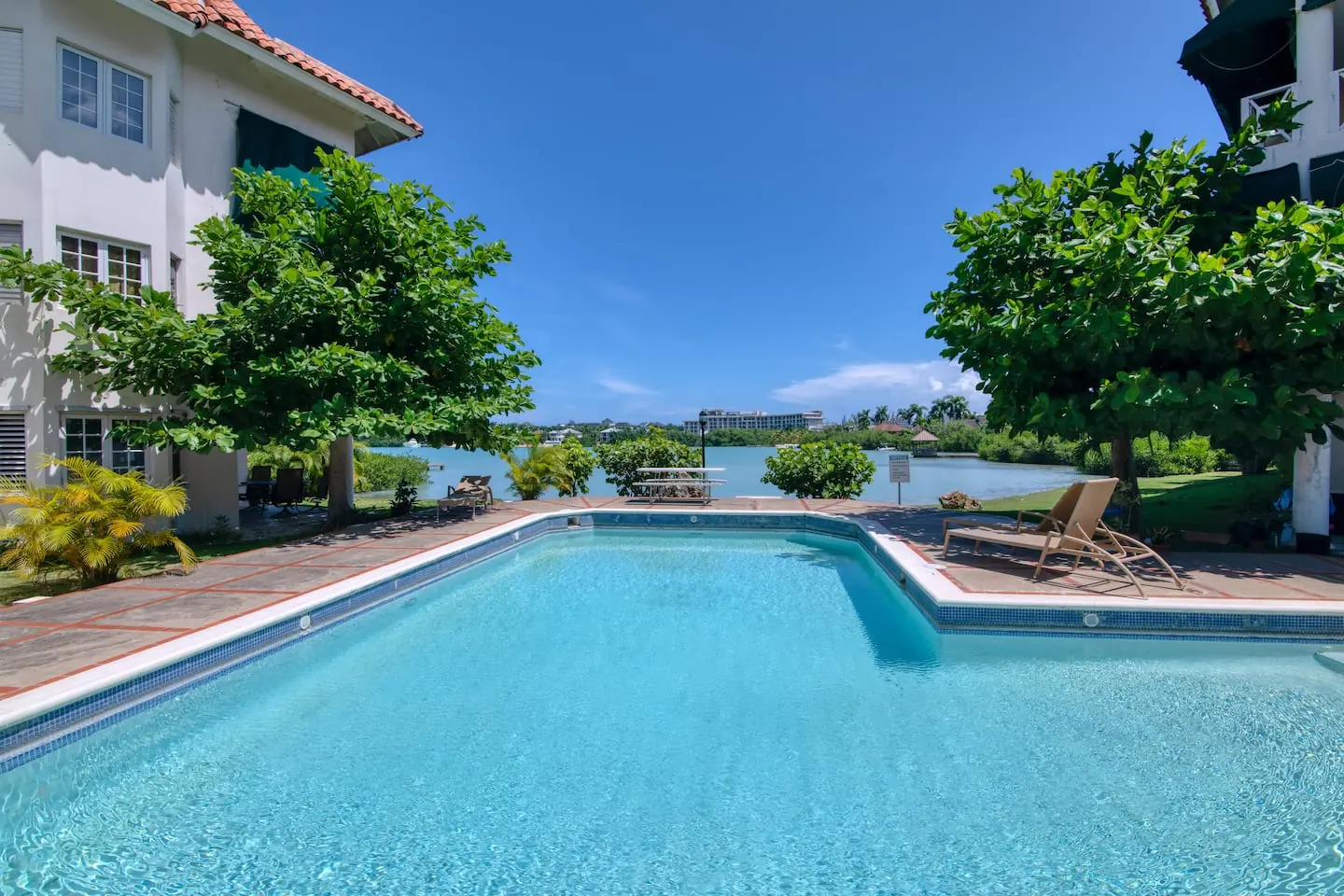 Shared pool and sun loungers overlooking the lagoon.